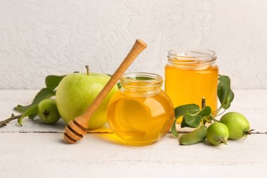 Beyaz ahşap masada Rosh Hashanah kutlaması (Yahudi Yeni Yılı) için elmalı bal kavanozları