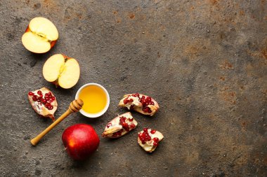 Rosh Hashanah kutlaması için bir kase nar ve elmalı bal (Yahudi Yeni Yılı) koyu arkaplanda