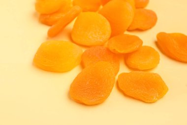 Tasty dried apricots on orange background