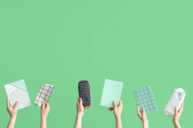 Hands with school accessories on green background