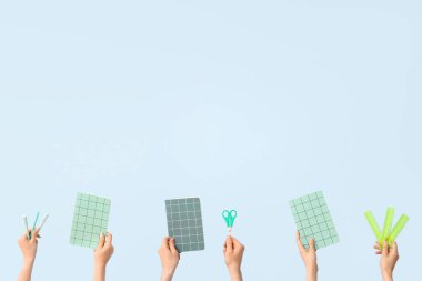 Hands with school supplies on blue background