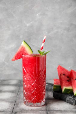 Bir bardak lezzetli karpuz suyu ve gri fayanslı nane.