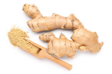 Taze zencefil kökleri ve beyaz arka planda kurutulmuş toz ile ahşap kepçe.