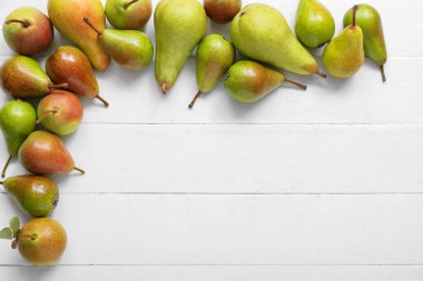 Beyaz ahşap masadaki olgun armutlardan yapılmış çerçeve