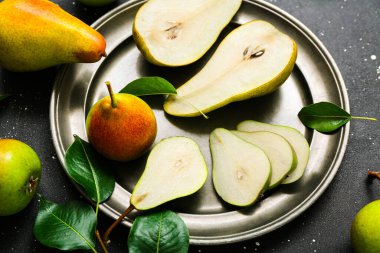 Siyah masada olgun armutlarla kaplanmış, yakın plan.