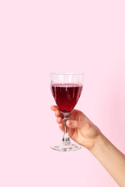 Vrouwelijke Hand Houden Glas Rode Wijn Roze Achtergrond — Stockfoto