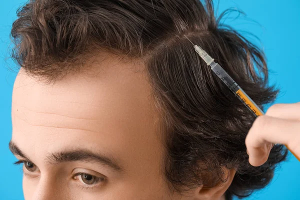 青の背景に注射を作る脱毛の問題を持つ若い男 クローズアップ — ストック写真