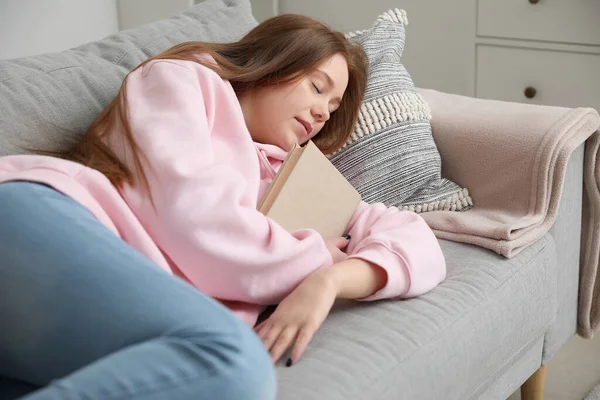 自宅でソファーで寝ている本を持つ十代の少女 — ストック写真