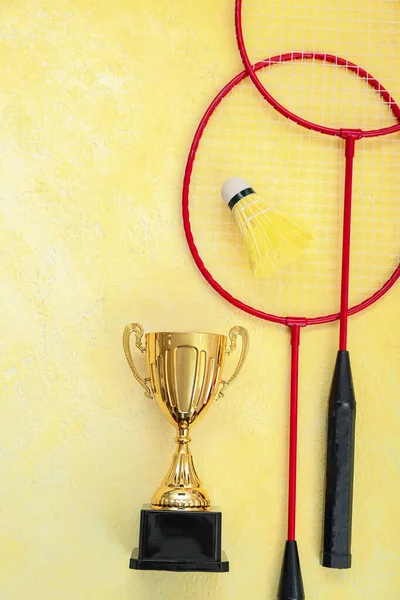 Copo Ouro Com Raquetes Badminton Shuttlecock Fundo Amarelo — Fotografia de Stock
