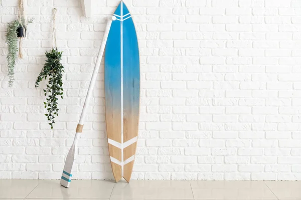 Kürekli Tahta Sörf Tahtası Odadaki Beyaz Tuğla Duvarda Bitkiler — Stok fotoğraf