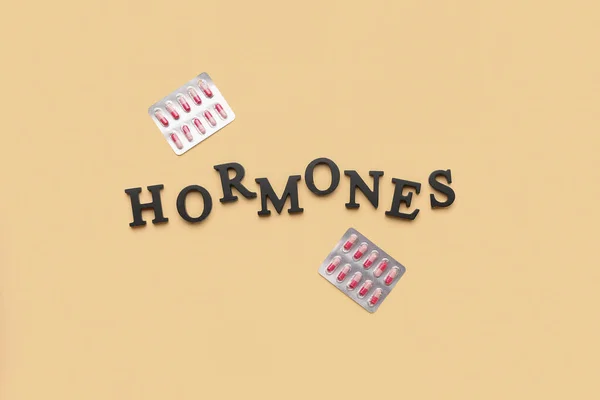 Word Hormones Pills Yellow Background — Stock Photo, Image