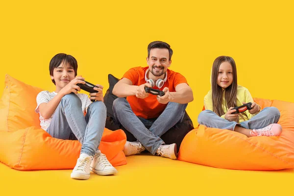 Vater Mit Seinen Kleinen Kindern Beim Videospiel Auf Gelbem Hintergrund — Stockfoto