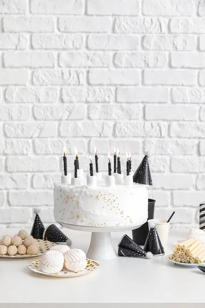 Verjaardagstaart Met Kaarsen Snoep Witte Tafel Buurt Van Bakstenen Muur — Stockfoto