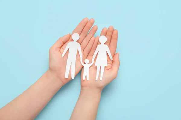 stock image Woman holding human figures on blue background. Family love concept
