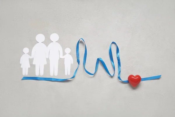 Family figures with ribbon in shape of diagram and heart on white background. Health care concept