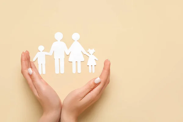 Weibliche Hände Mit Familienfiguren Auf Beigem Hintergrund Versicherungskonzept — Stockfoto