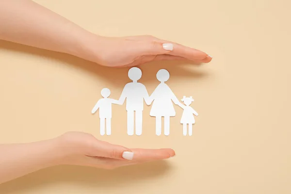 Vrouwelijke Handen Met Familiefiguren Beige Achtergrond Verzekeringsconcept — Stockfoto