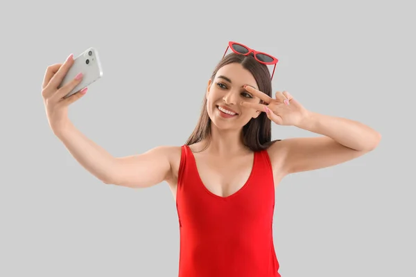 Mladá Žena Plavkách Mobilním Telefonem Přičemž Selfie Světlém Pozadí — Stock fotografie