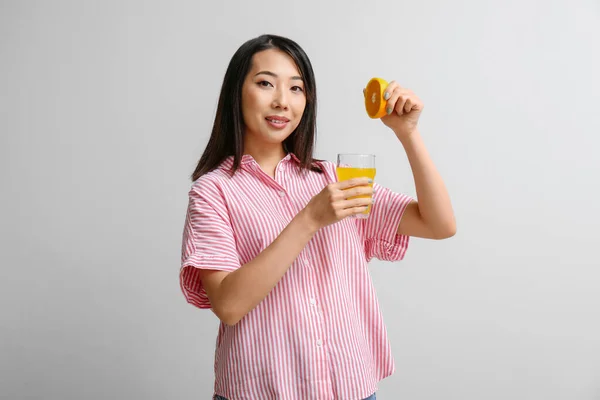 Красива Азіатська Жінка Апельсином Склянкою Соку Світлому Фоні — стокове фото