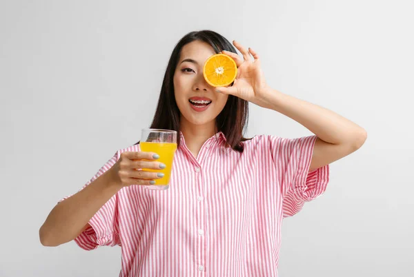 Mooie Aziatische Vrouw Met Sinaasappel Glas Sap Lichte Achtergrond — Stockfoto