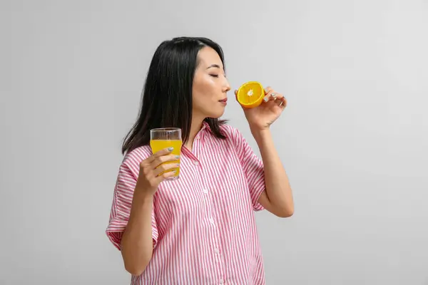 Mooie Aziatische Vrouw Met Sinaasappel Glas Sap Lichte Achtergrond — Stockfoto