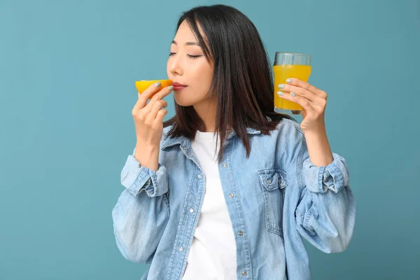 Mooie Aziatische Vrouw Met Sinaasappel Glas Sap Blauwe Achtergrond — Stockfoto