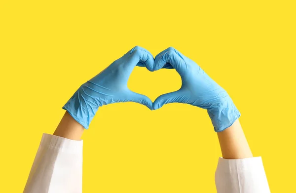 Female Doctor Hands Gloves Making Heart Gesture Yellow Background — Stock Photo, Image