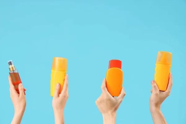 Vrouwelijke Handen Met Flessen Zonnebrandcrème Blauwe Achtergrond — Stockfoto