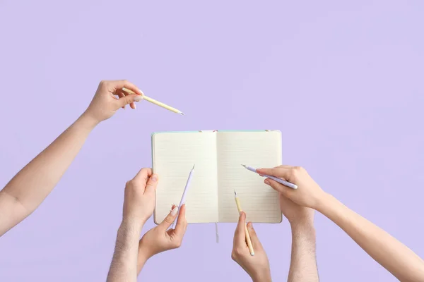 Muitas Mãos Com Canetas Escrevendo Caderno Branco Sobre Fundo Lilás — Fotografia de Stock