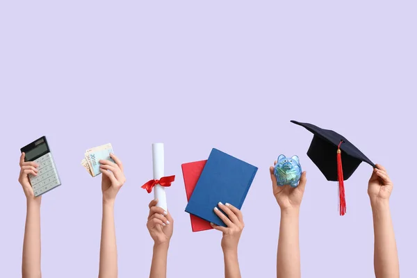 手握储蓄罐 毕业帽 毕业文凭和紫丁香背景的女性手 学生贷款概念 — 图库照片
