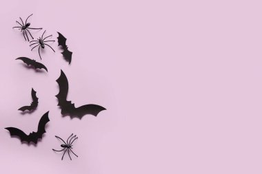 Cadılar Bayramı partisi için eflatun arka planda kağıt yarasalar ve örümcekler.