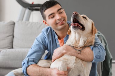 Evinde şirin Labrador köpeği olan genç adam, yakın plan.