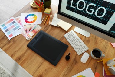 Ofiste bilgisayar, tablet ve boya paletleri ile grafik tasarımcısının çalışma yeri