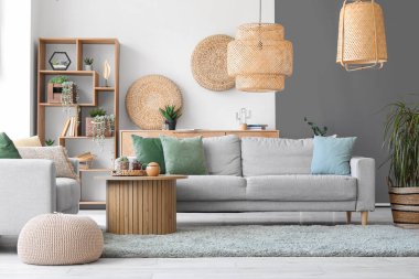 Sade gri koltukları ve yumuşak halılı kahve masası olan şık bir oda.