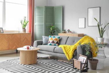 Işıl ışıl oturma odası, rahat gri kanepe ve kahve masası.