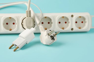 Mavi arka planda prizleri olan güç soketi. Elektrik faturası kavramı