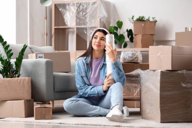 Taşındığı gün evinde streç film sarılı genç bir kadın hayal ediyor.