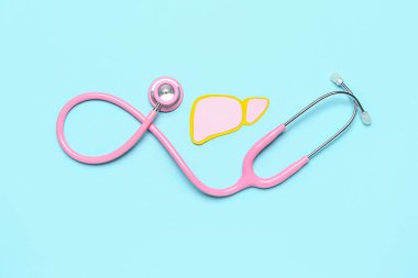 Mavi arka planda steteskoplu pembe kağıt karaciğer.