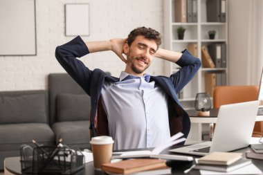 Genç işadamı ofiste dinleniyor.