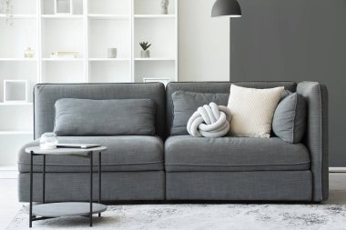 Işıl ışıl oturma odası, rahat gri kanepe ve kahve masası.