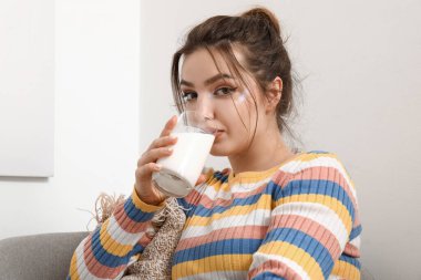 Evde süt içen genç bir kadın, yakın plan.