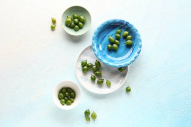 Açık mavi arka planda taze bektaşi üzümlü tabaklar ve kaseler.