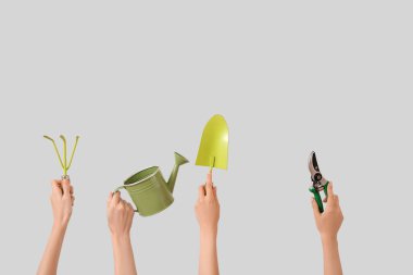 Arka planda farklı bahçe aletleri olan kadınlar