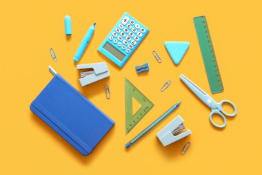 Turuncu arka planda farklı okul kırtasiyesi ve defter