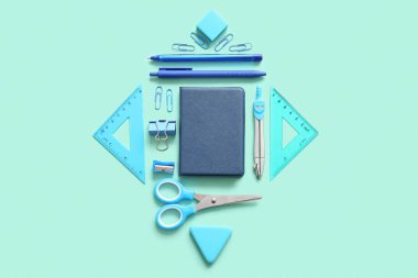 Turkuaz arka planda farklı okul kırtasiyesi ve defter