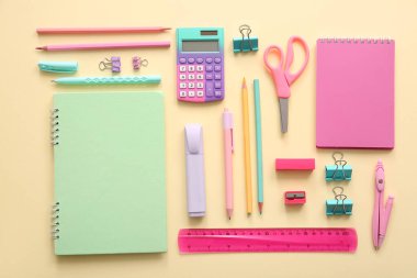 Bej arka plan üzerine farklı okul kırtasiyesi ve not defterleri