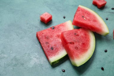 Yeşil zemin üzerinde olgun karpuz parçaları olan kompozisyon, yakın plan.