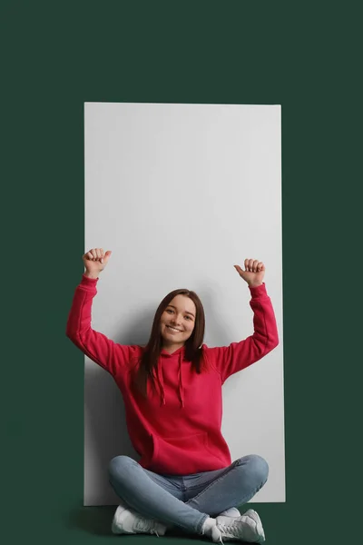 Young Woman Hoodie Pointing Big Blank Poster Green Background — Stock Photo, Image
