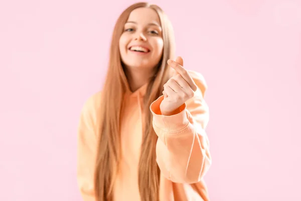 Молодая Женщина Капюшоне Придает Форму Сердцу Рукой Розовом Фоне — стоковое фото