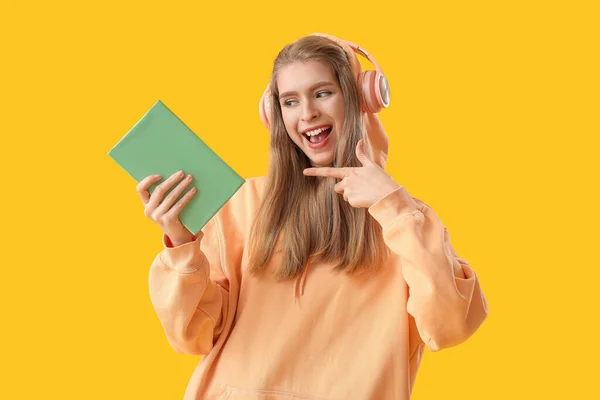 Sarı Arka Plan Kitabını Gösteren Genç Bir Kadın — Stok fotoğraf